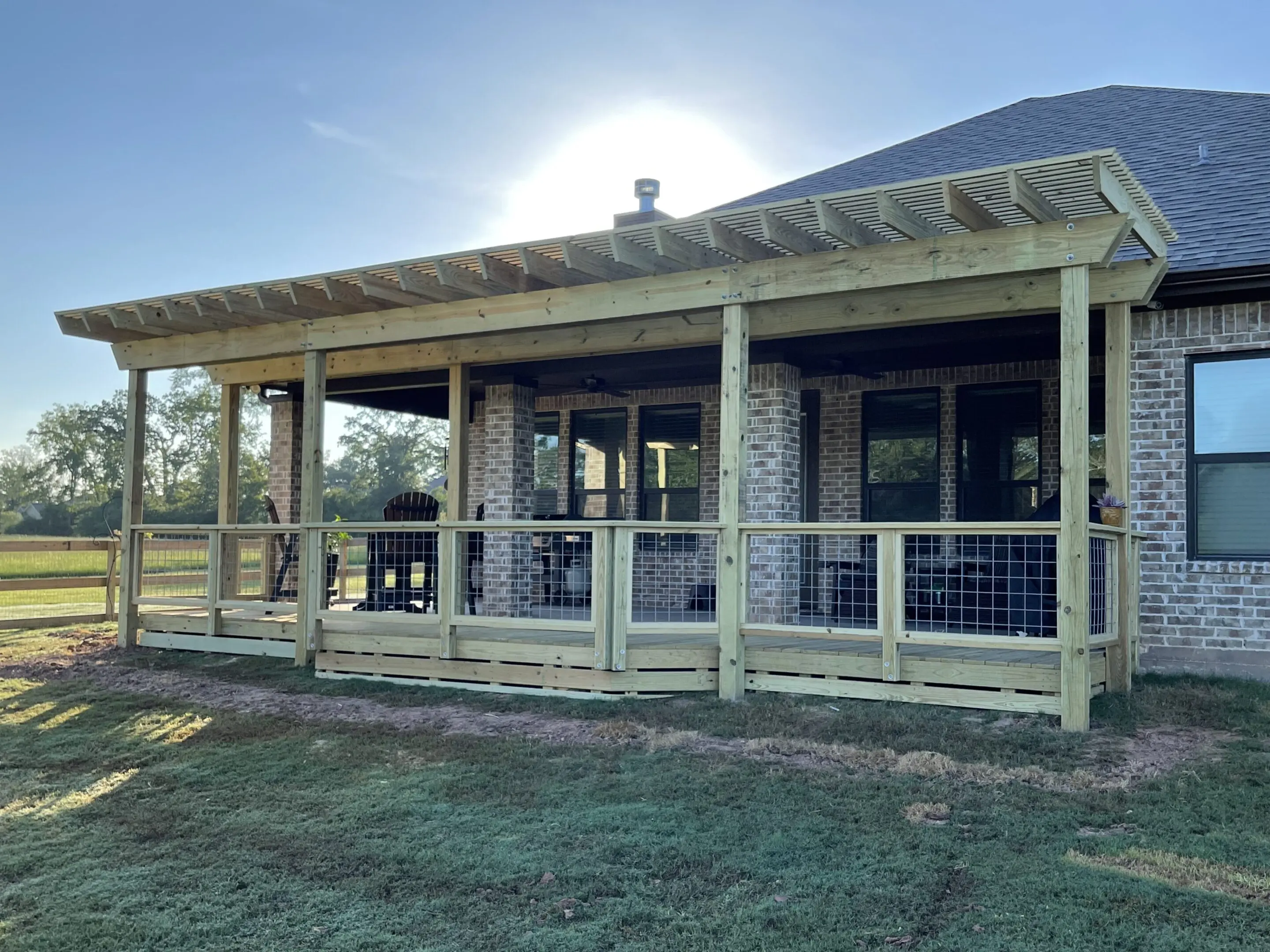 A cozy porch on a modern house with a metal roof and wooden railing.