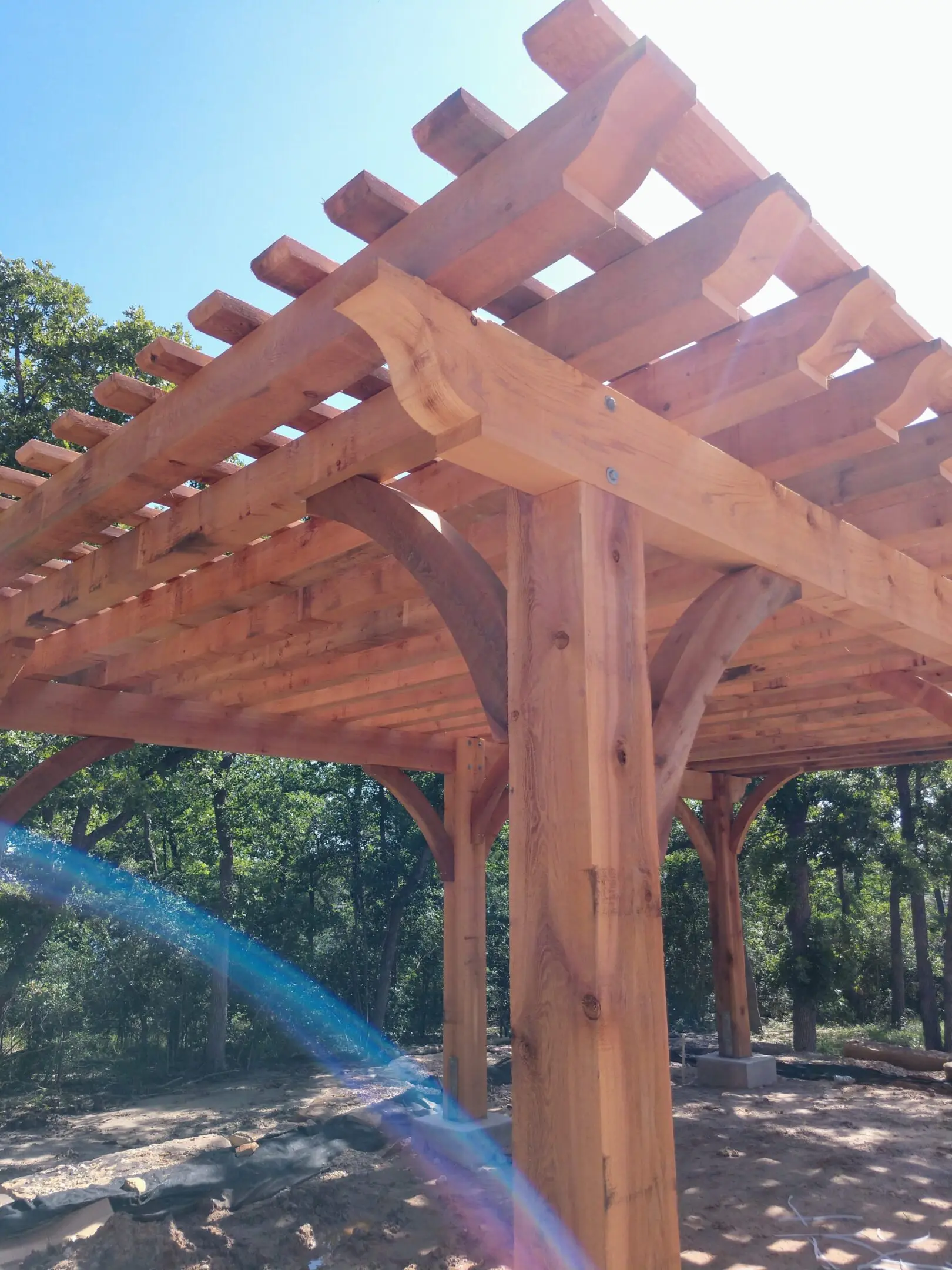 Close-up of wooden pergola beams and joints in sunlight.