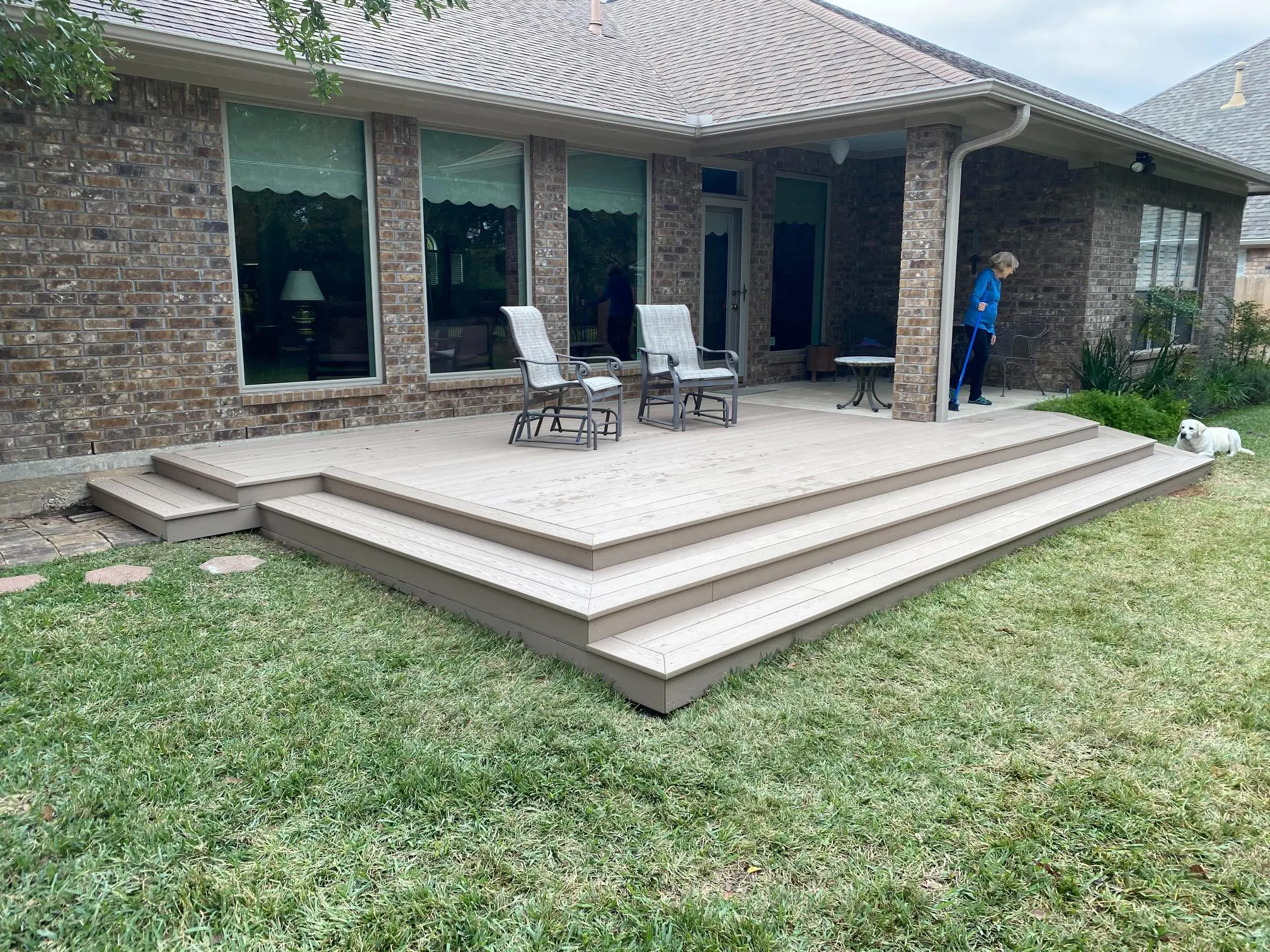 A modern patio with a multi-level wooden deck and outdoor furniture.