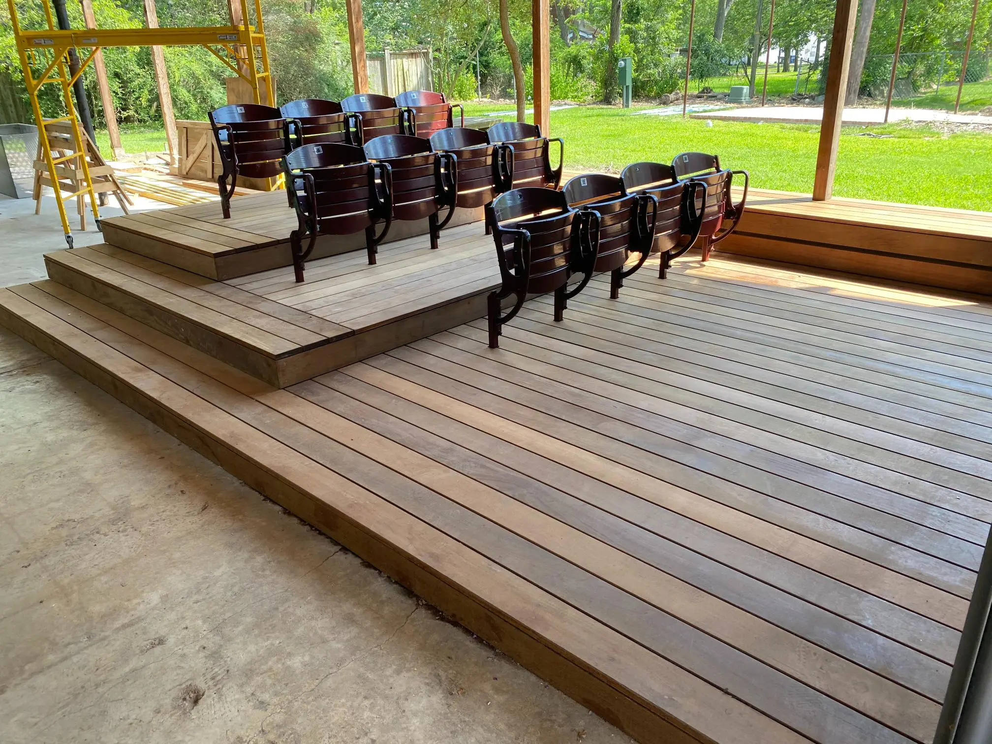 Wooden tiered seating with a scenic outdoor view of greenery.
