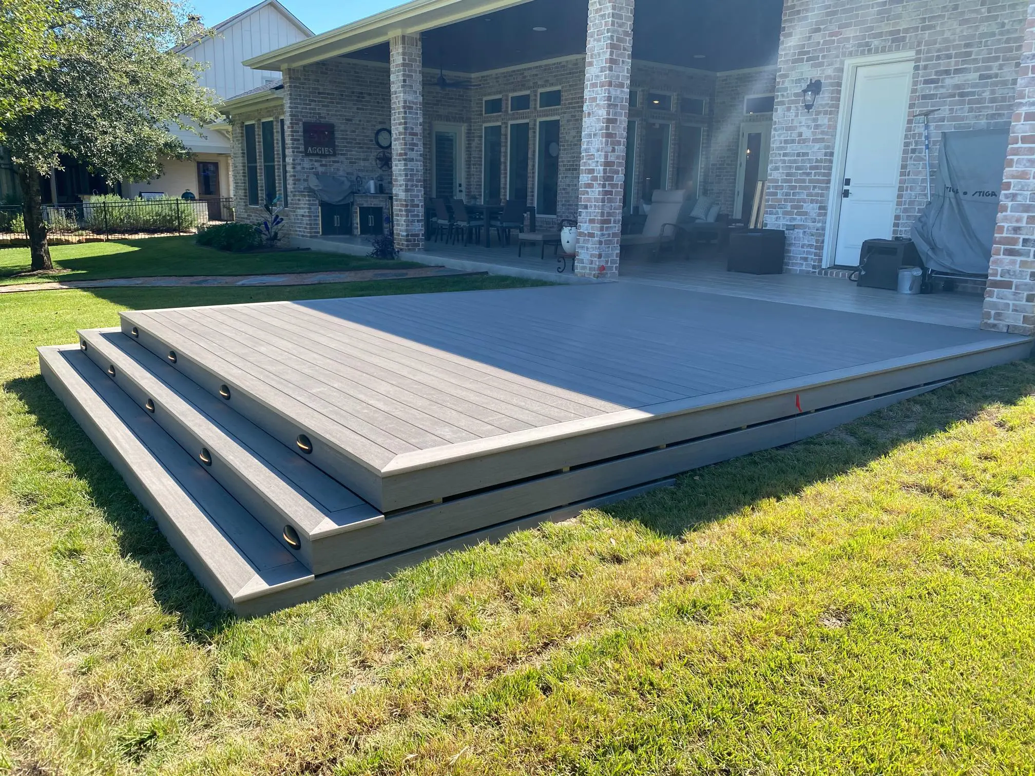 Modern raised deck with clean lines beside a house.