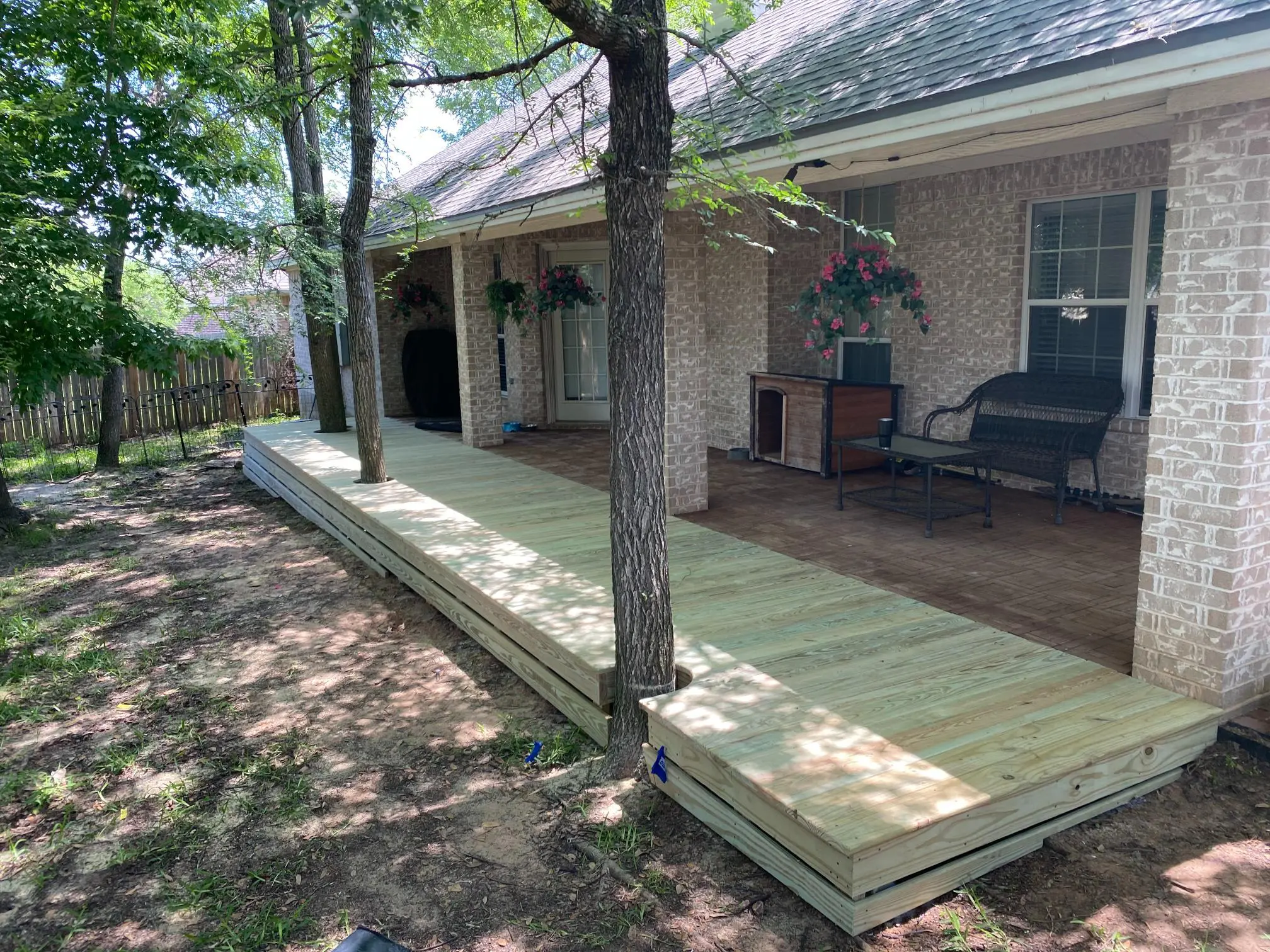 New wooden deck built alongside a house in a backyard.