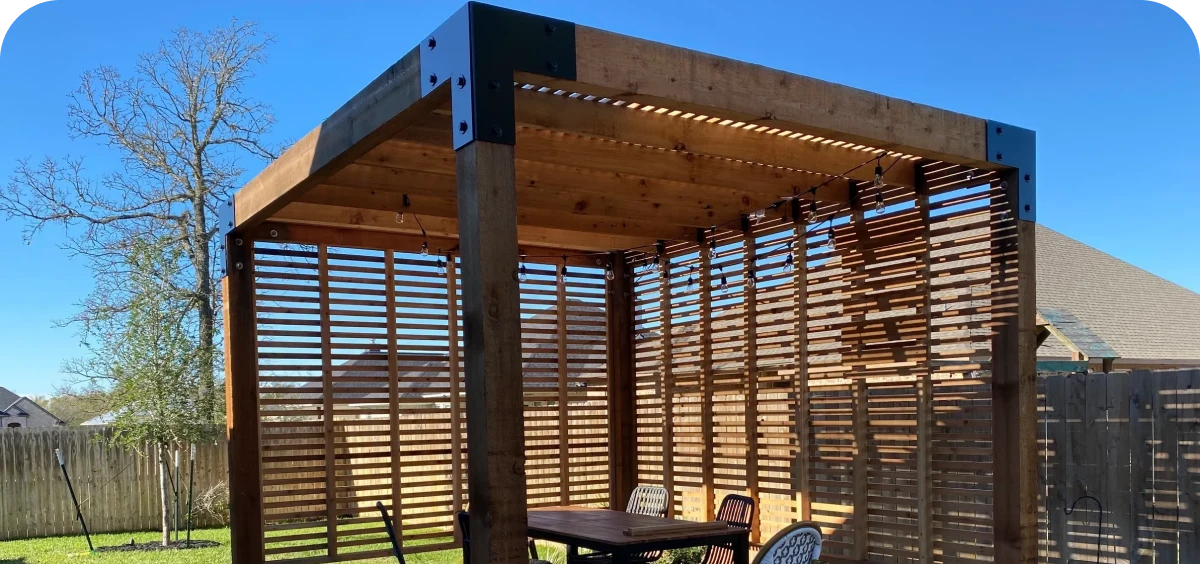 Wooden pergola with patio furniture underneath.